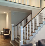 Exposed wood stairway with white painted banister by Mad Hatter